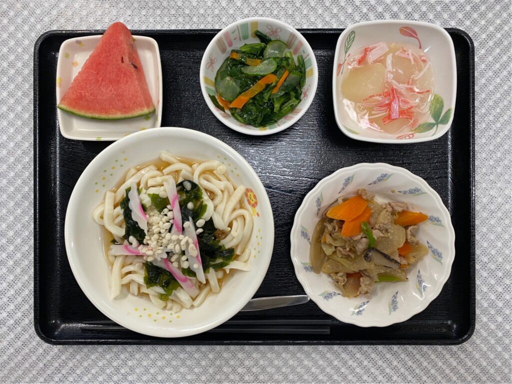 7月15日月曜日　きょうのお昼ごはんは、たぬきうどん・豚肉と根菜の炒め物・冬瓜のくずあん・青菜和え・くだものでした。