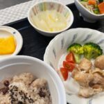 11月29日金曜日　きょうのお昼ごはんは、お赤飯・鶏肉の香草焼き・和え物・くずあん・きのこ汁・くだものでした。